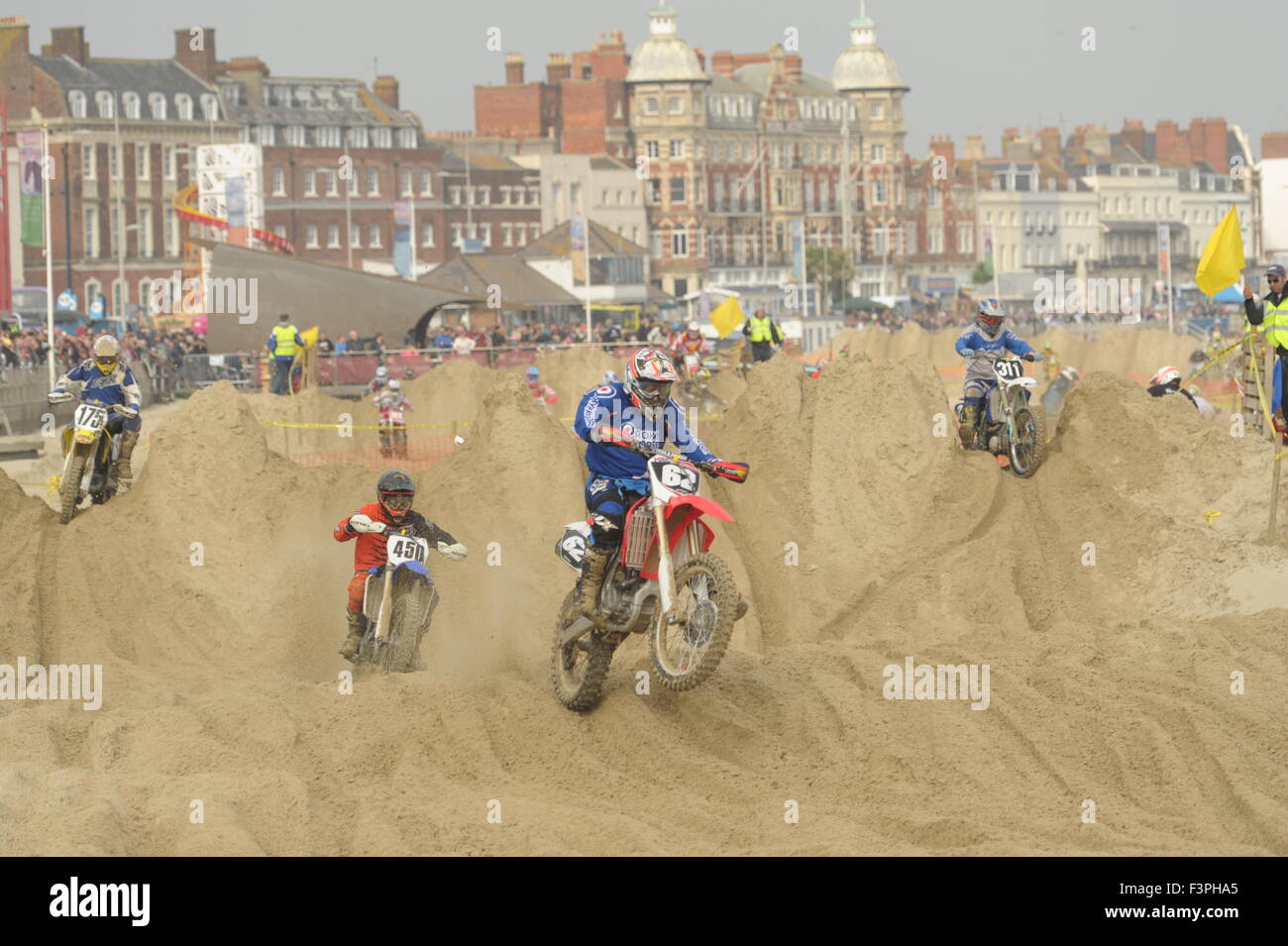 Weymouth, Dorset, Reino Unido - 11 de octubre de 2015. La Playa de León anual de fin de semana de motocross en la playa de Weymouth. Weymouth & Portland Lion's organizar conjuntamente el evento popular con Purbeck Motocross club que atrae a cientos de jinetes, que ponerse a prueba a sí mismos en el complicado curso de playa - jinetes compiten en curso con el fondo espectacular de Weymouth playa - Imagen: Graham Hunt/Alamy Live News Foto de stock