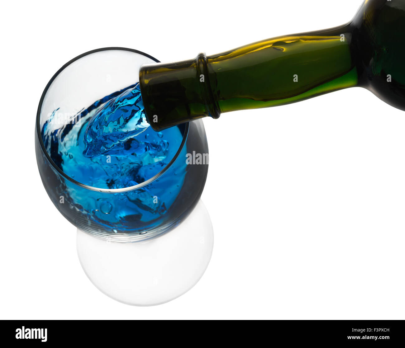 Beber alcohol azul vertiendo en un vaso aislado en el fondo blanco. Foto de stock