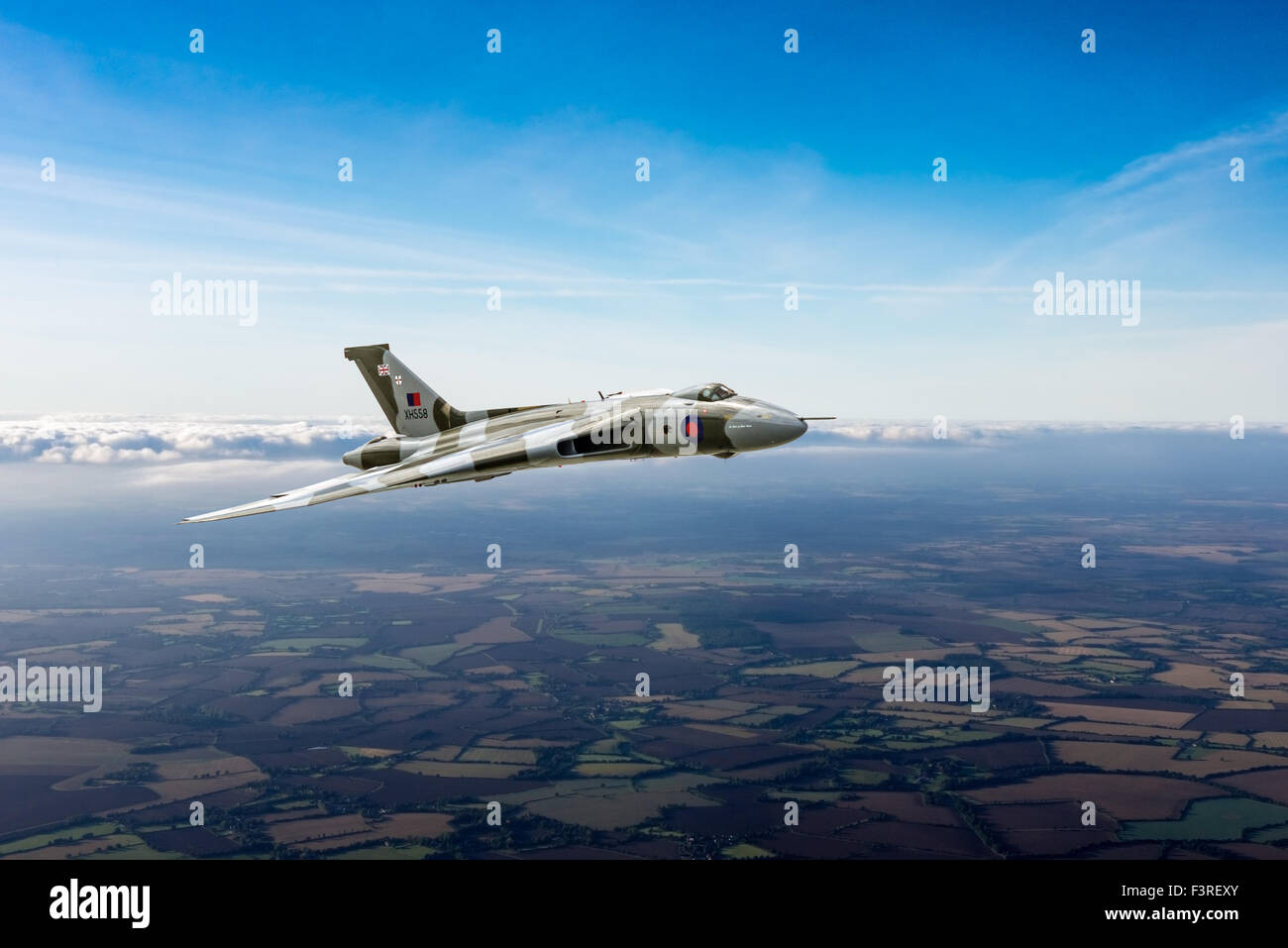 Una representación de un Avro Vulcan ala delta bombardero estratégico en los cielos de la campiña británica. Foto de stock