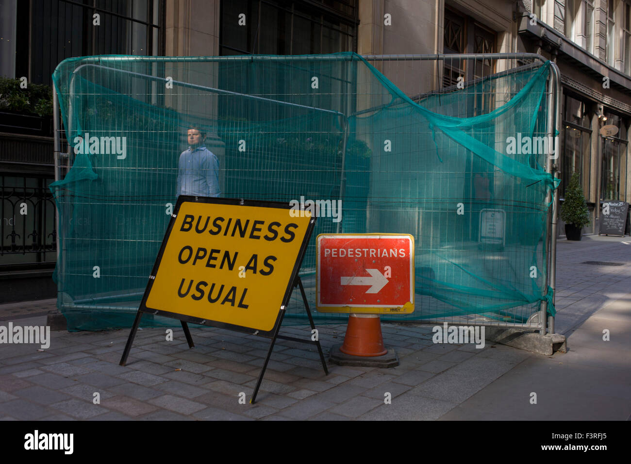 Un letrero que dice que los negocios abiertos como es habitual se encuentra en una estrecha calle de la ciudad de Londres. Foto de stock