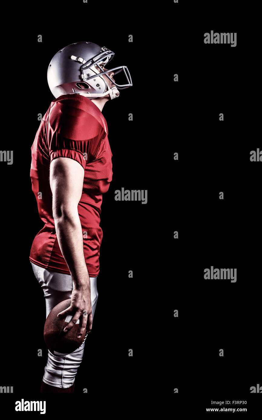 Imagen compuesta de jugador de fútbol americano mientras está de pie mirando hacia arriba Foto de stock
