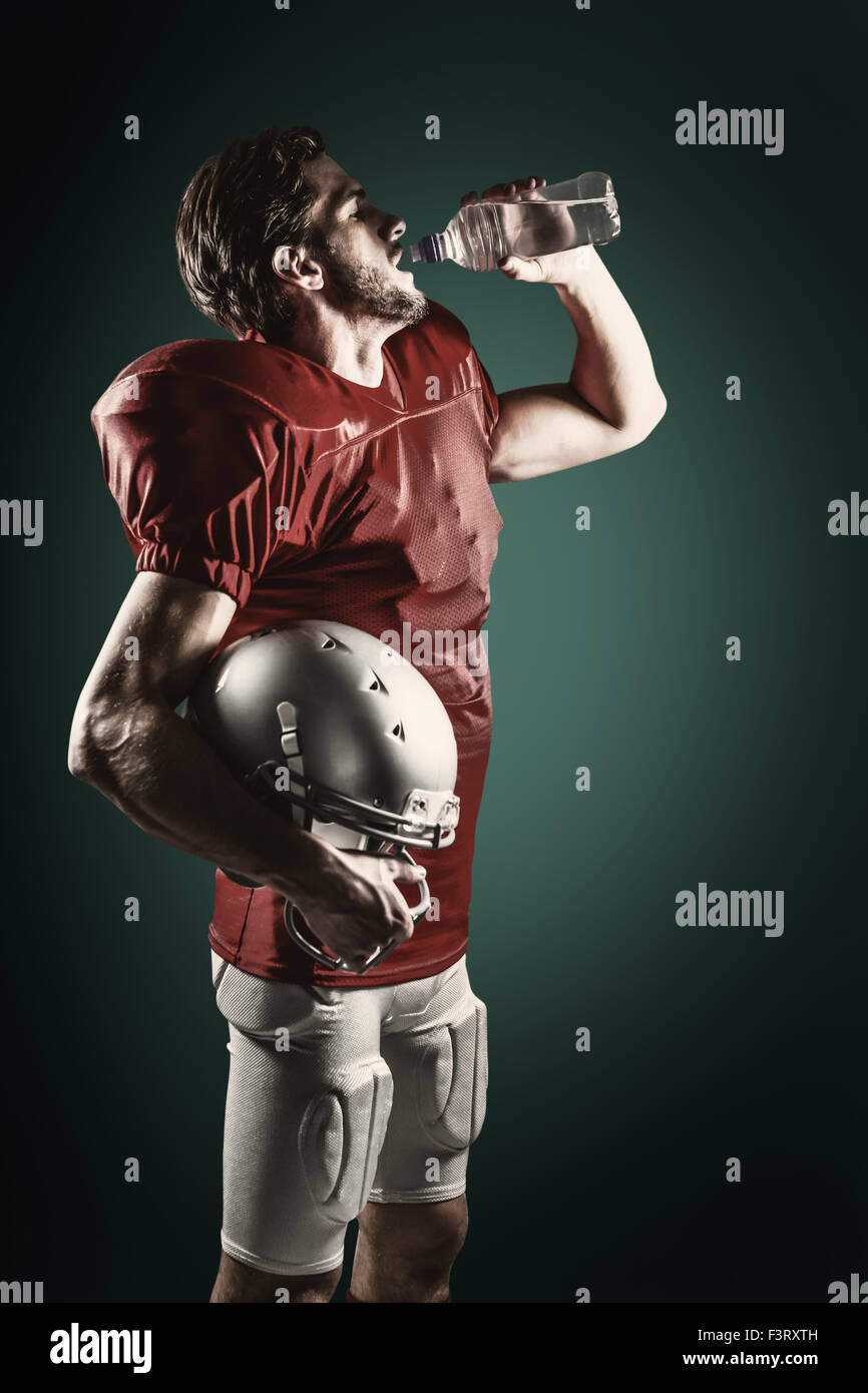 Imagen compuesta de sed, jugador de fútbol americano en rojo jersey de agua potable Foto de stock