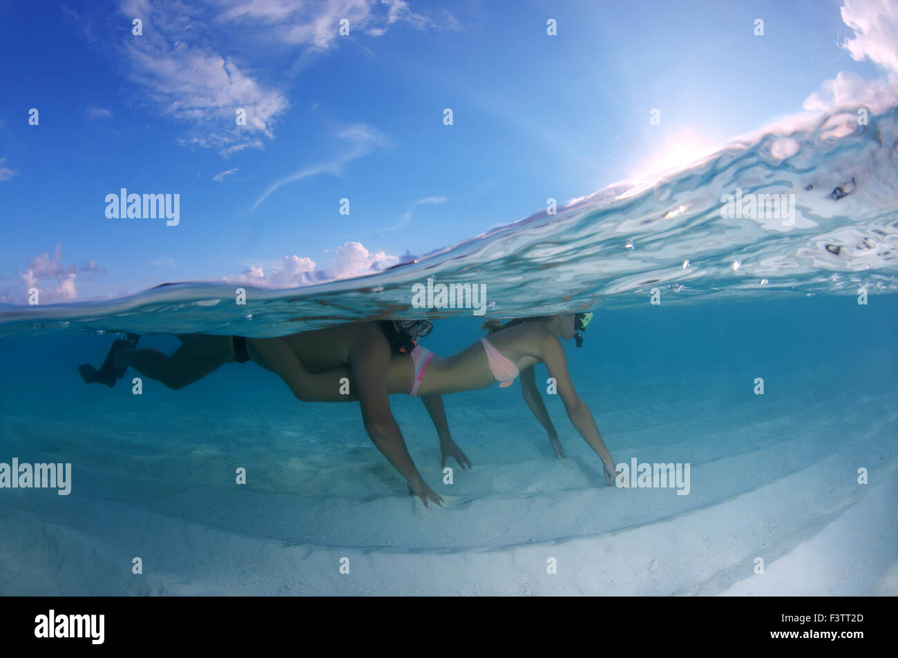 Hermosa joven pareja flotando sobre un fondo arenoso, el Océano Índico, Maldivas Foto de stock