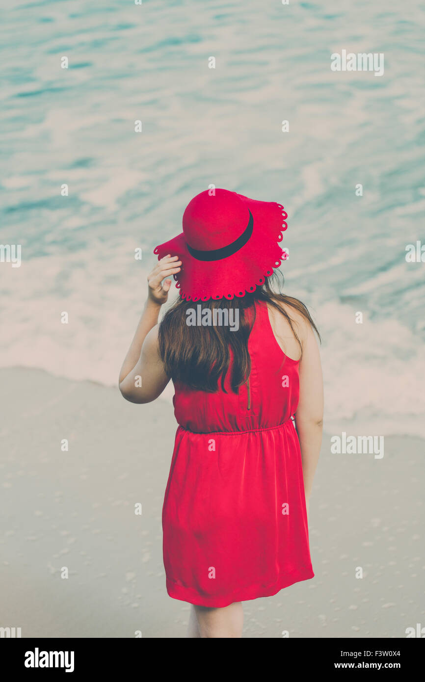 Mujer joven un vestido rojo en playa de stock - Alamy