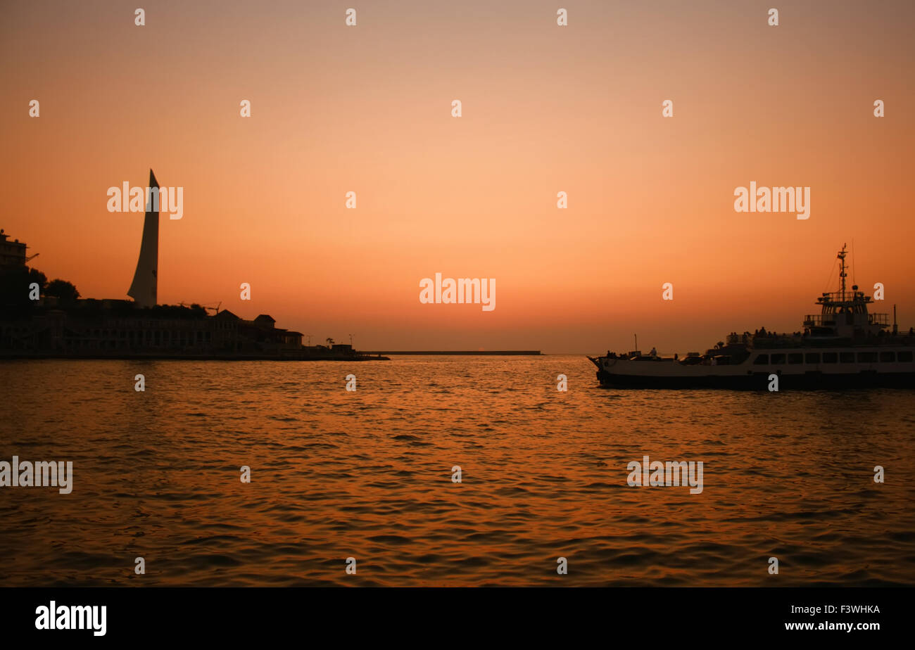 Sunset mar con barco que cruza la bahía Foto de stock
