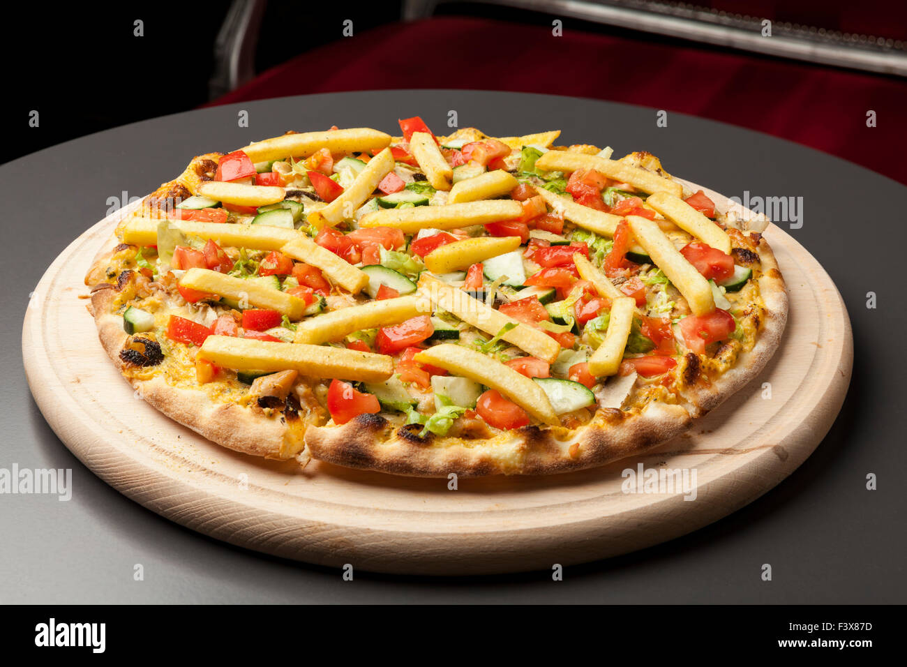Pizza vegetariana con pepino, tomate y patatas fritas Foto de stock