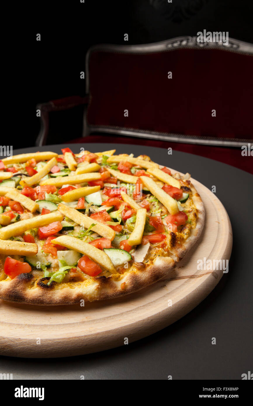 Pizza vegetariana con pepino, tomate y patatas fritas Foto de stock