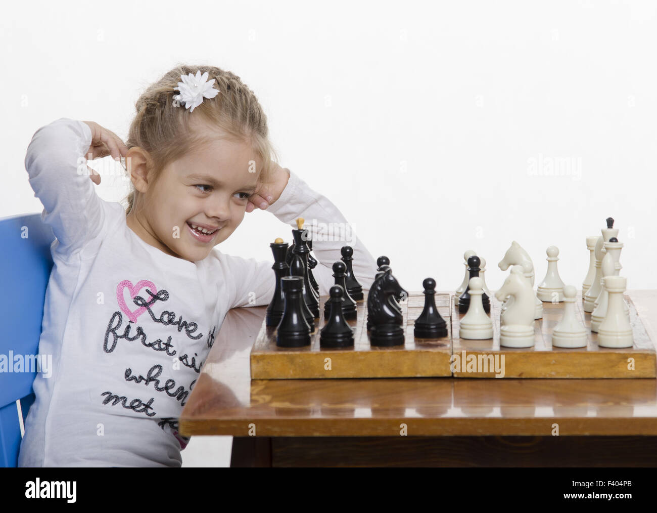 Niña jugando ajedrez en un buen humor. Foto de stock