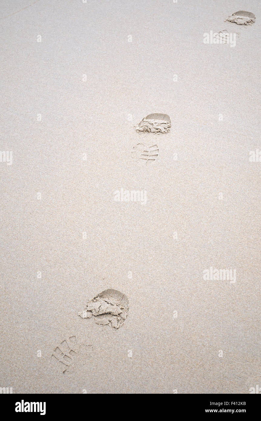 Diagonal trazas en wet white sand Foto de stock
