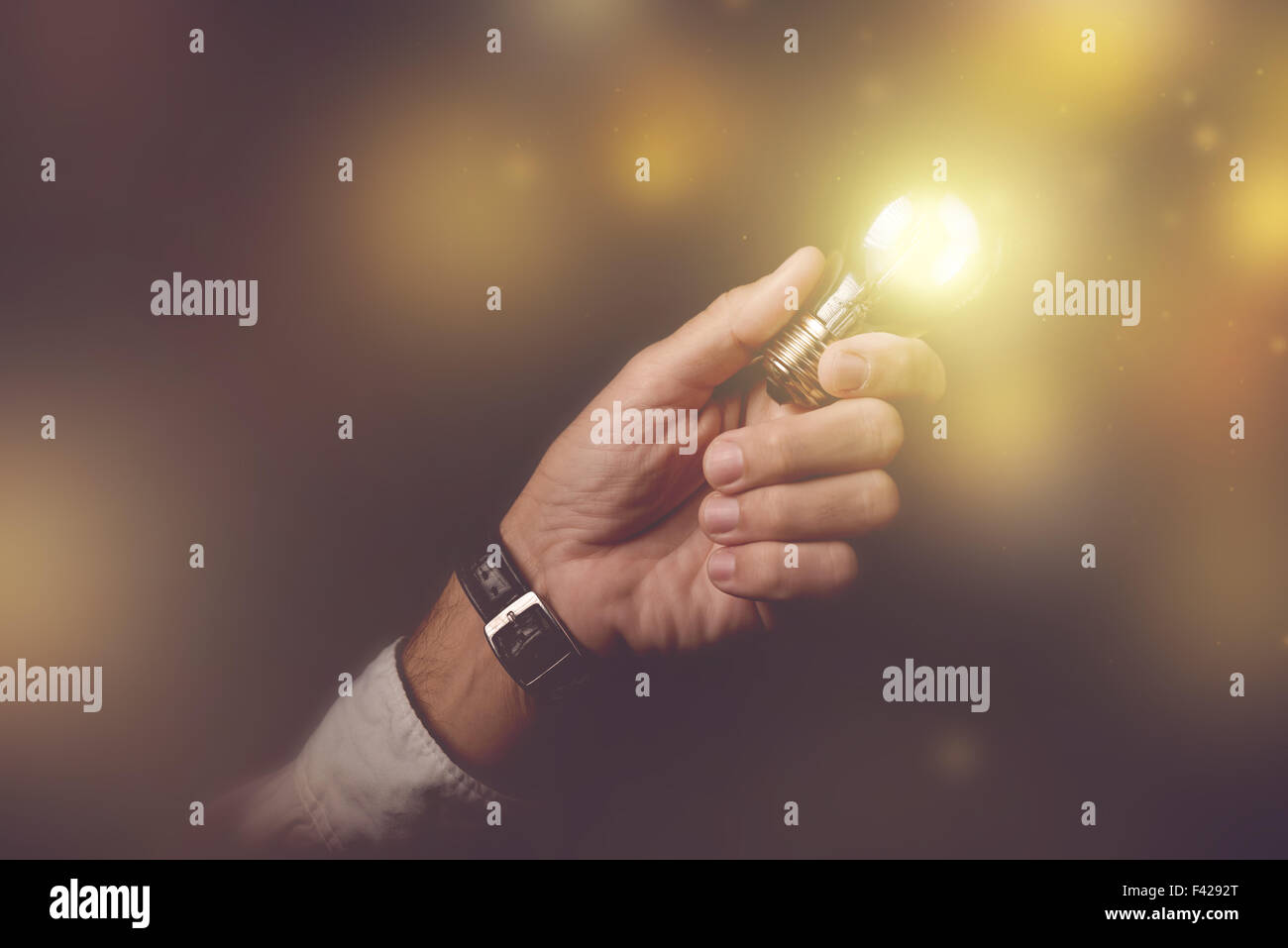 Gran idea de negocio metáfora visual, empresario con bombilla rayo hasta el interior de la oficina del oscuro, imagen, selecti tonos retro Foto de stock