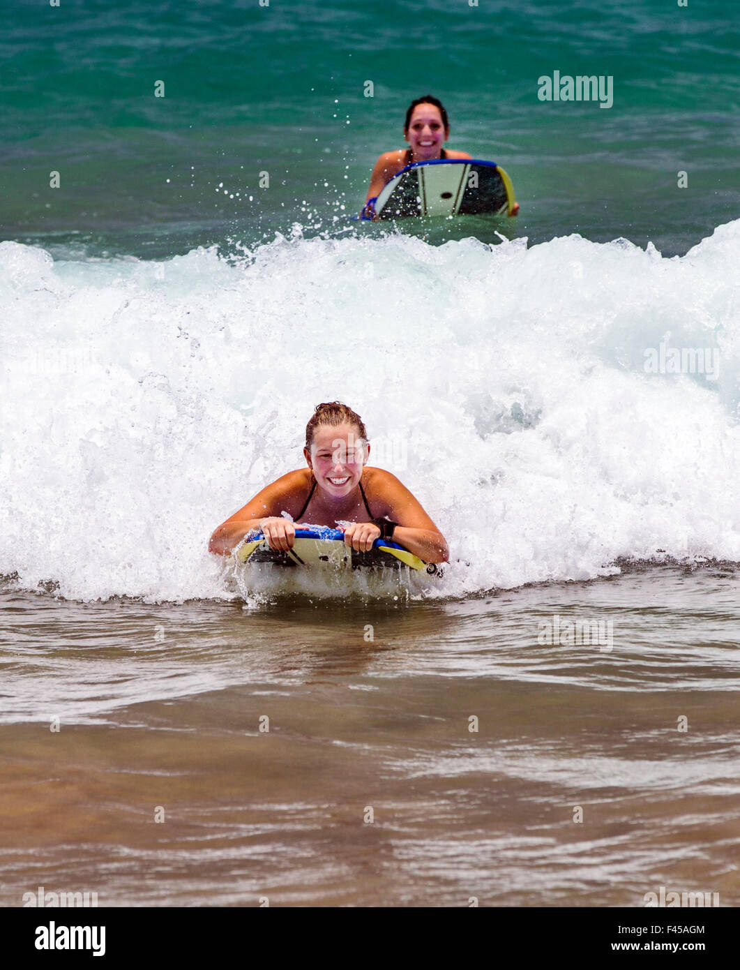 Las niñas olas para practicar surfing, Hapuna Beach, Costa Kohala, Hawai'i, EE.UU. Foto de stock