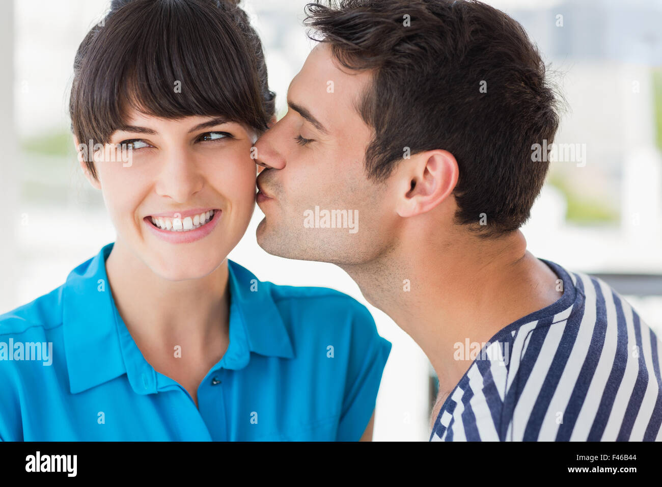 Joven diseñador sorprendió obteniendo un beso de un trabajador de co Foto de stock