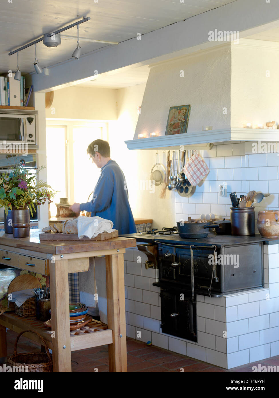 Una mujer en una cocina, Skane, Suecia. Foto de stock
