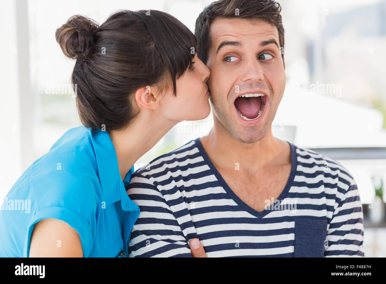 Joven diseñador sorprendió obteniendo un beso de un trabajador de co Foto de stock
