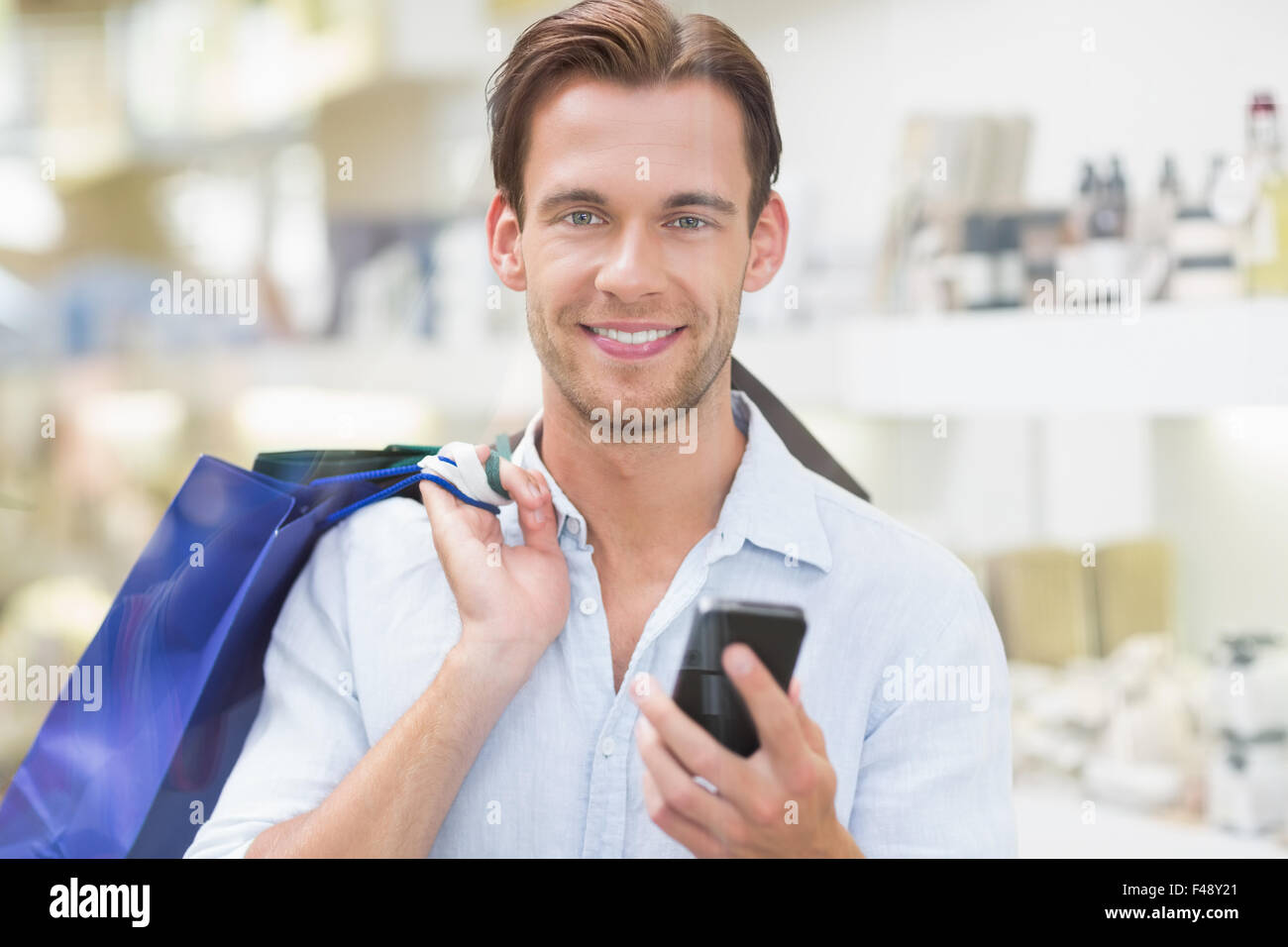 Un hombre sonriendo feliz mirando el teléfono Foto de stock