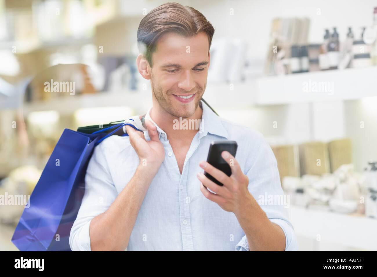 Un hombre sonriendo feliz mirando el teléfono Foto de stock
