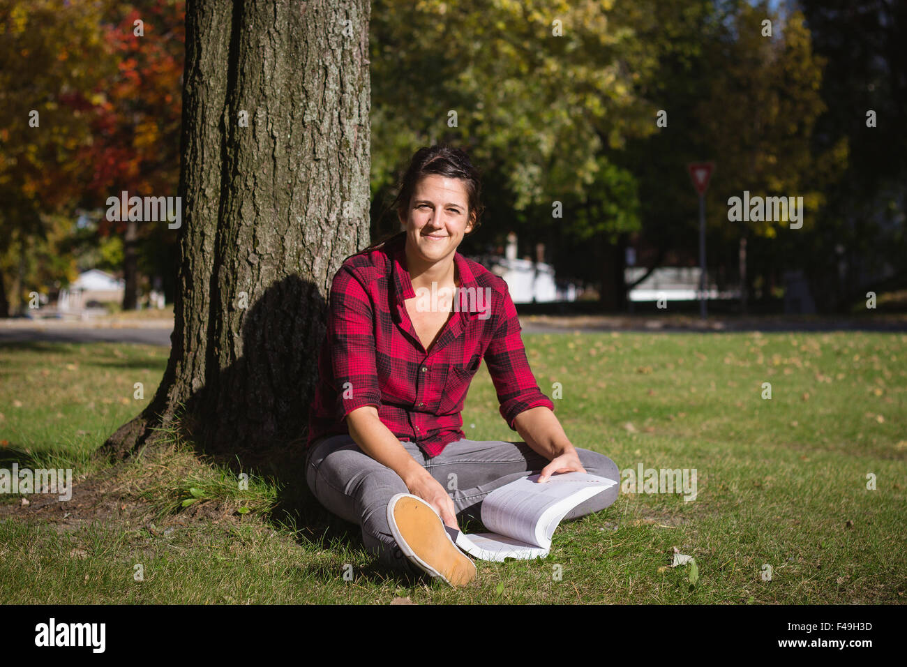 Las mujeres que estudian en el exterior de libros escolares caen en el día Foto de stock