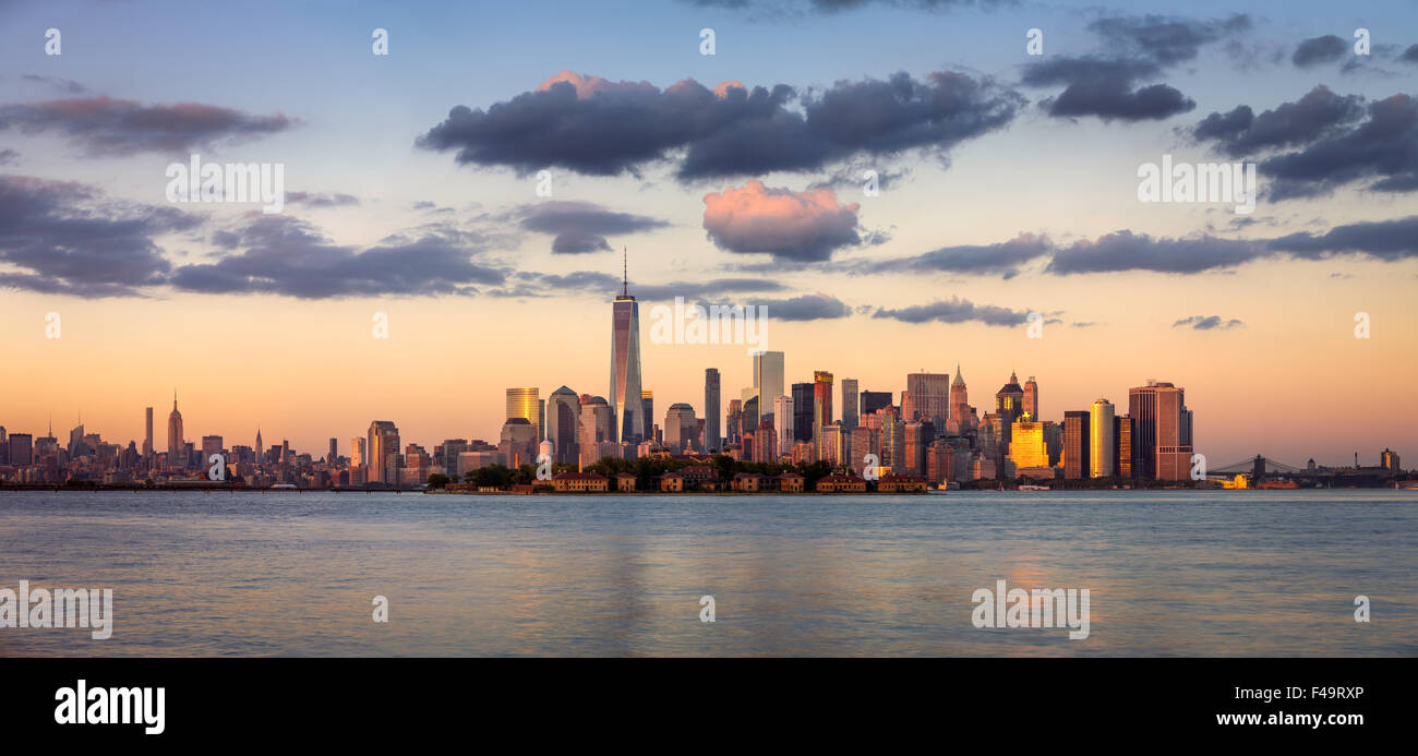 Rascacielos de Manhattan, el Distrito Financiero y la isla de Ellis panorama al atardecer, la ciudad de Nueva York, EE.UU. Foto de stock