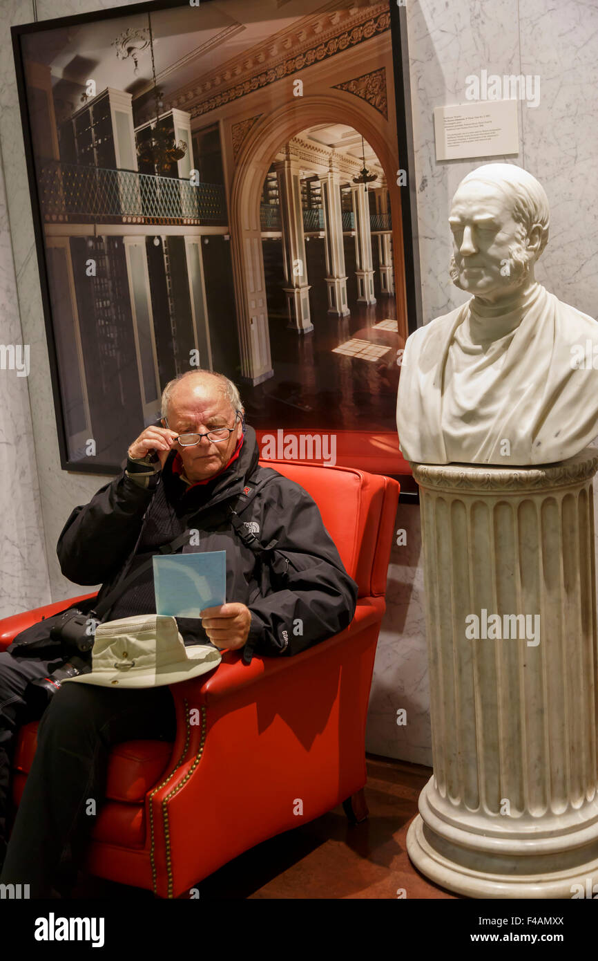 Senior de llevar gafas hombre sentado leyendo en el Boston Athenaeum Foto de stock