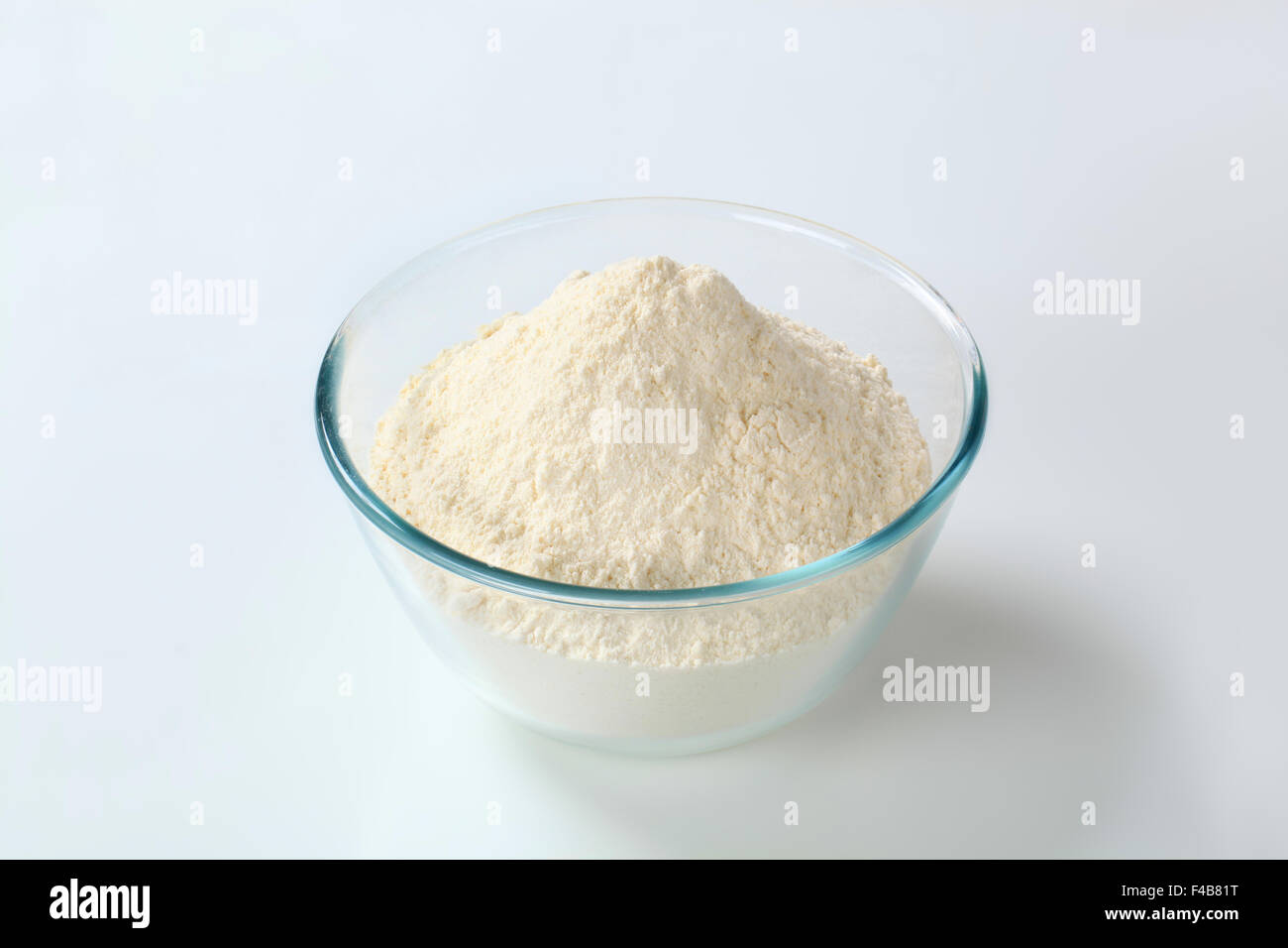 La harina de trigo blanco en un pequeño tazón de vidrio. Foto de stock