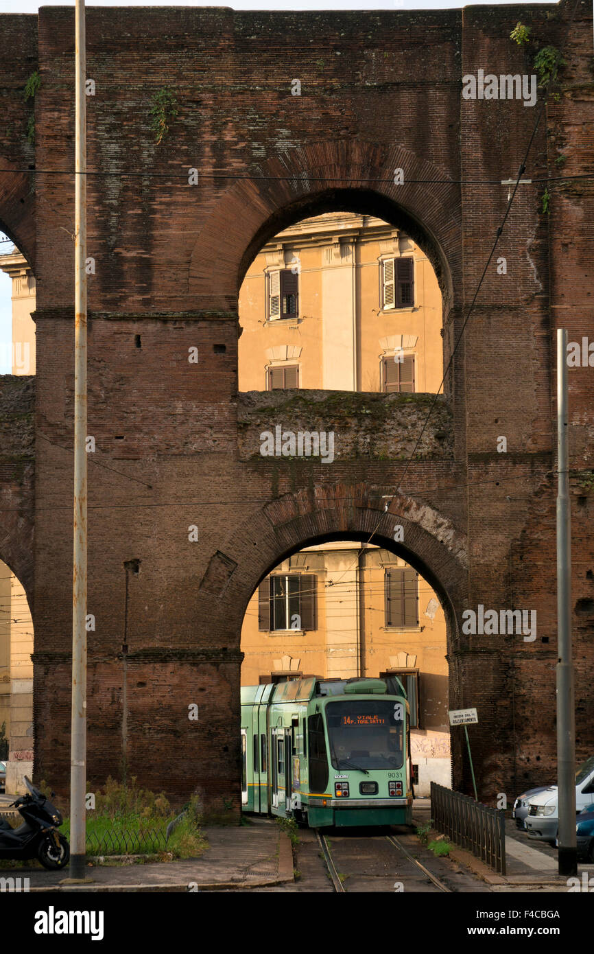 Tranvía pasando bajo el Acueducto Romano en Porta Maggiore, la puerta oriental de la ciudad de la antigua Roma, Italia Foto de stock