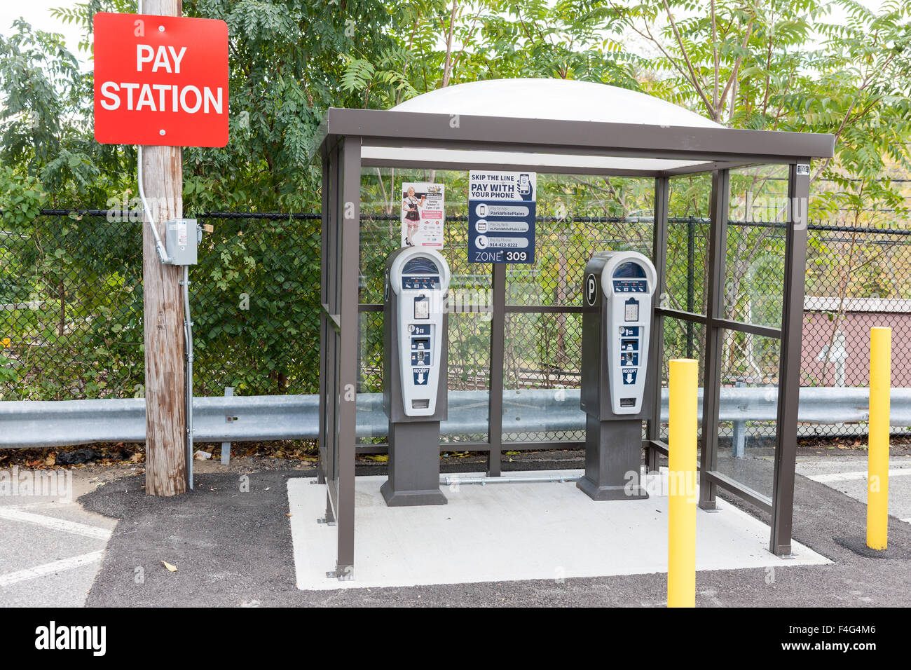 Un multi-espacio de aparcamiento estación de pago sirve un taxímetro mucho en el norte Metro-North White Plains estación en White Plains, Nueva York. Foto de stock