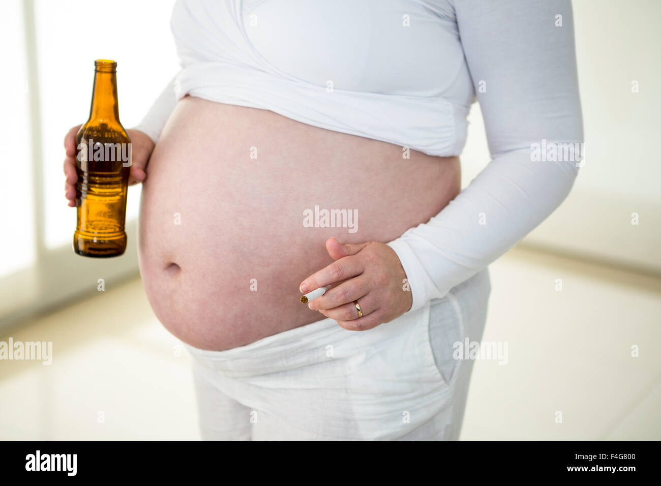 Linda mujer embarazada la celebración de cigarrillos y cerveza