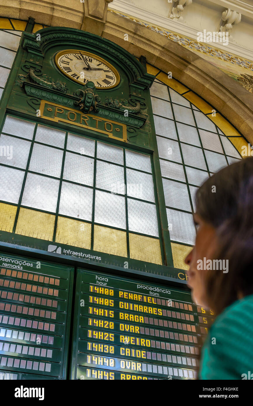 Mujer lee los horarios de tren junta en la estación de trenes de Sao Bento. Octubre, 2015. Porto, Portugal Foto de stock