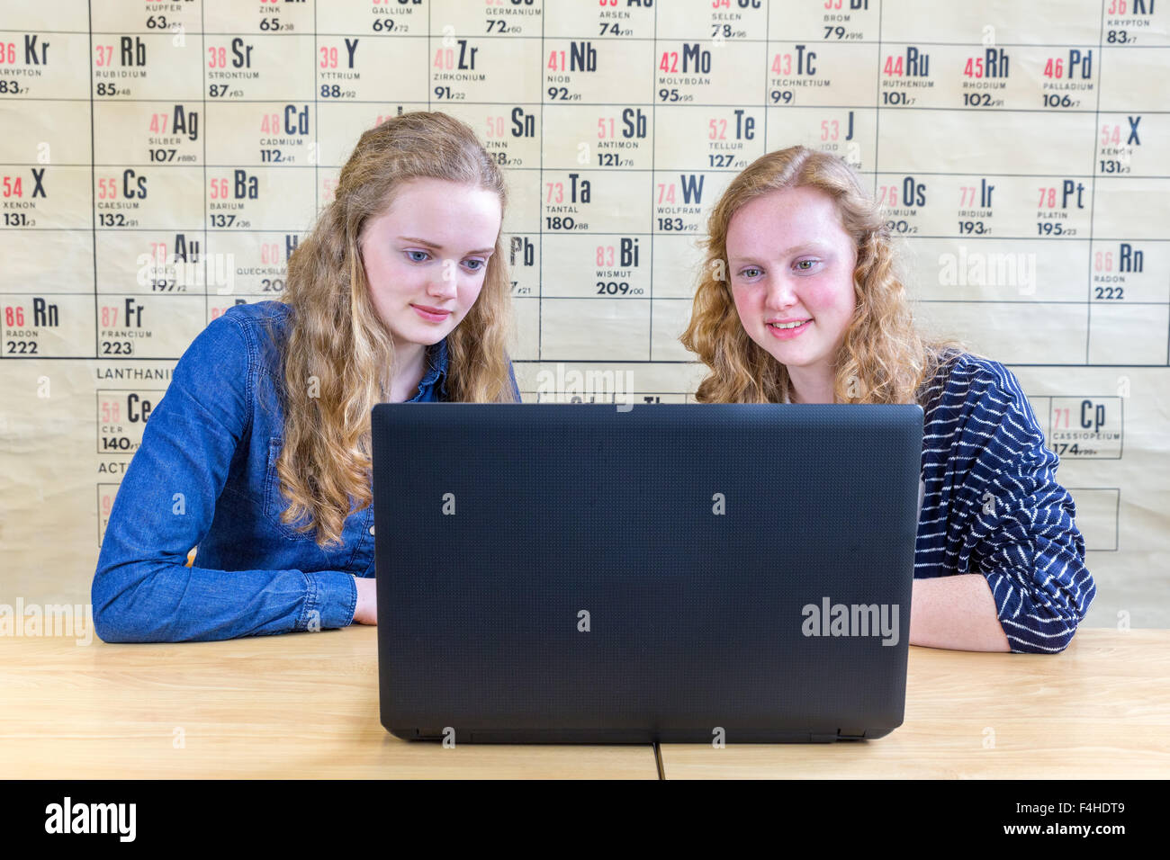 Dos Chicas Adolescentes Caucásicos Mirando Portátil En Clase De Química