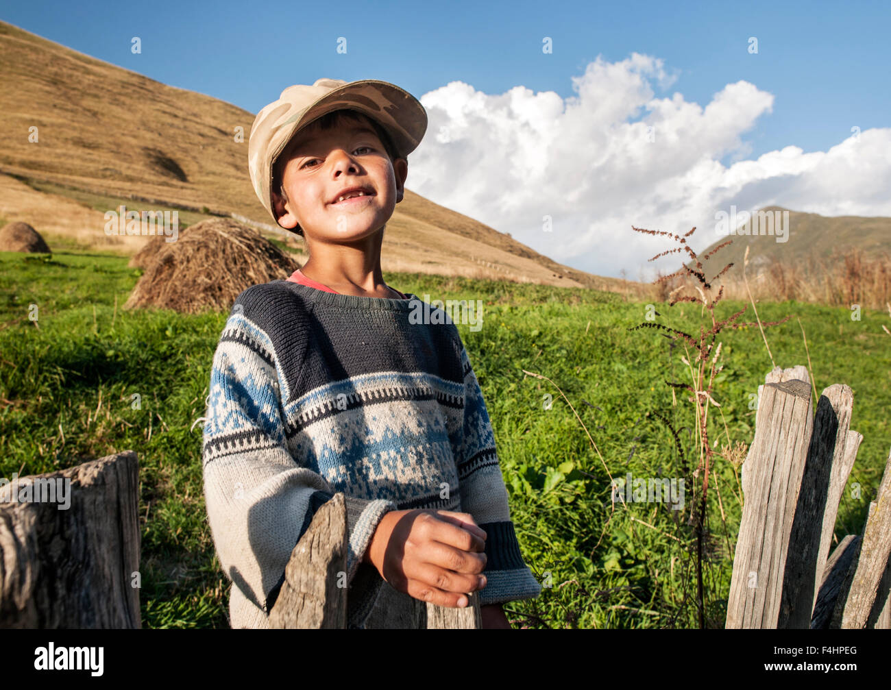 Un niño plantea en las afueras de Ushguli aldea en la región del noroeste de Georgia Svaneti. Foto de stock