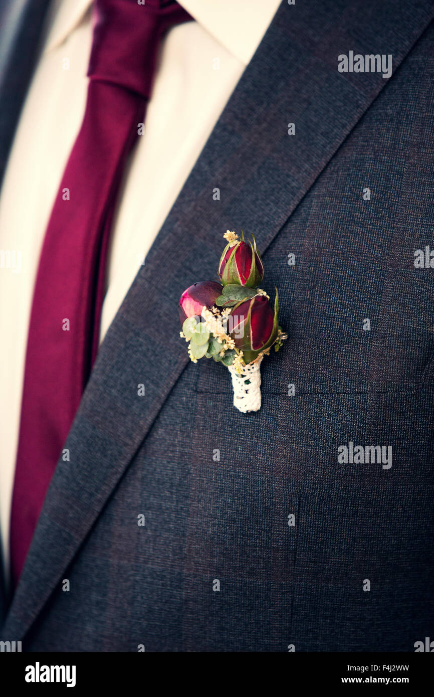 Rosal arreglo floral para la solapa del novio en traje gris Fotografía de  stock - Alamy