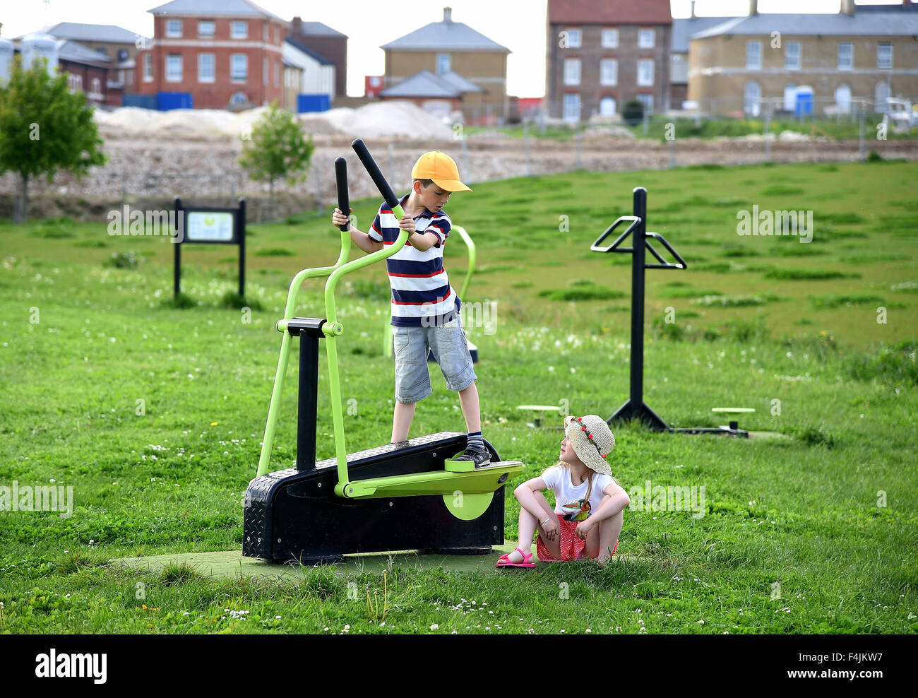 Los niños juegan en el Gran Campo en aldea Poundbury, Dorset, Inglaterra, Reino Unido Foto de stock