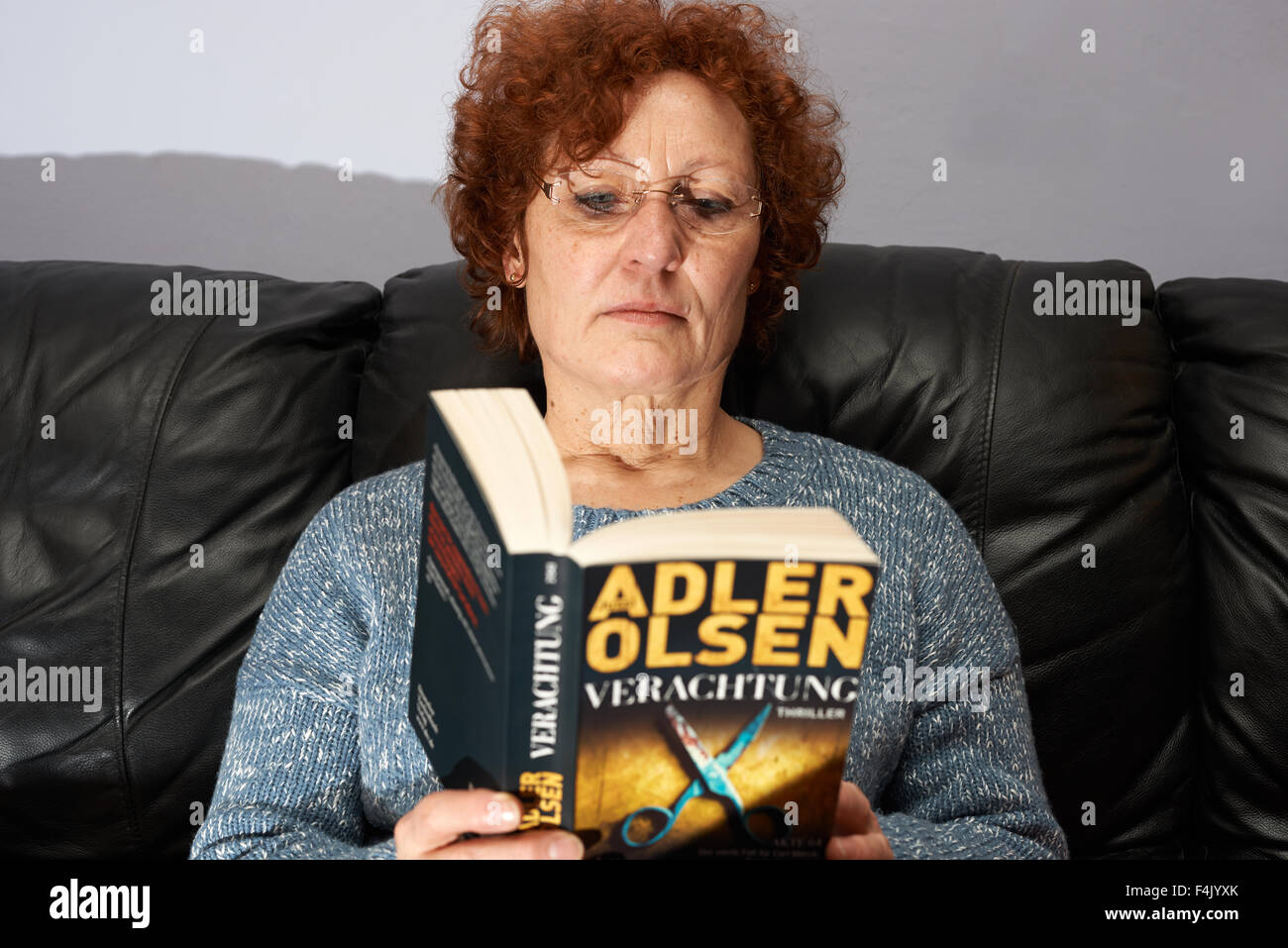 La mujer en el hogar lectura Adler Olsen "thriller Verachtung' Foto de stock