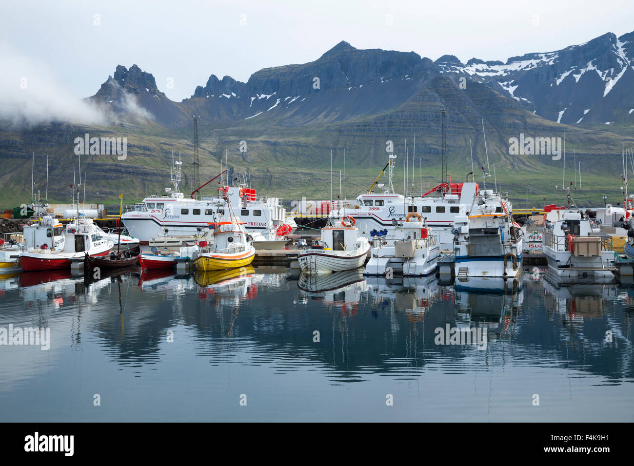 Barcos de pesca se refleja en puerto, Austurland Stodvarfjordur, Islandia. Foto de stock