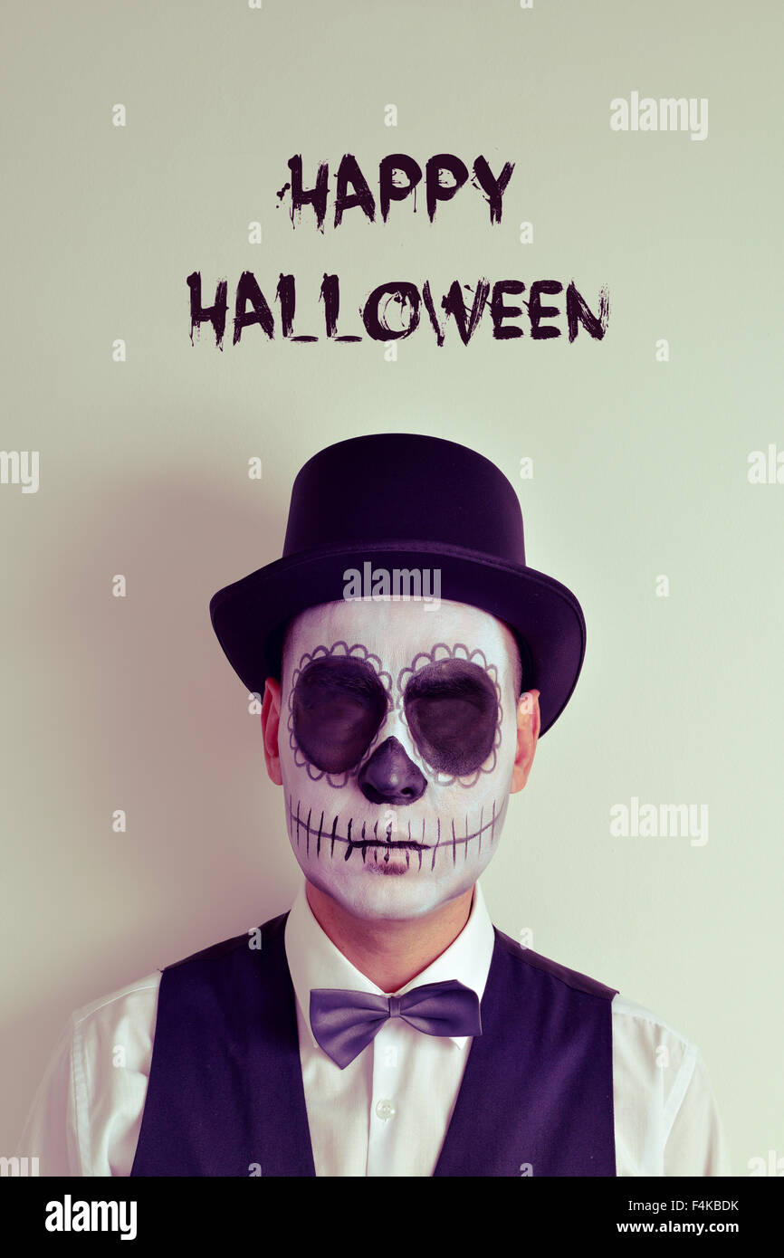 Retrato de un hombre con calaveras maquillaje sin ojos, luciendo pajarita y  sombrero de copa, y el texto feliz halloween Fotografía de stock - Alamy