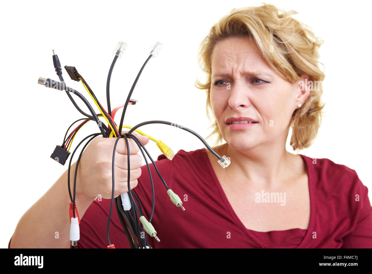 Mujer mirando desconcertados por muchos coloridos cables Foto de stock