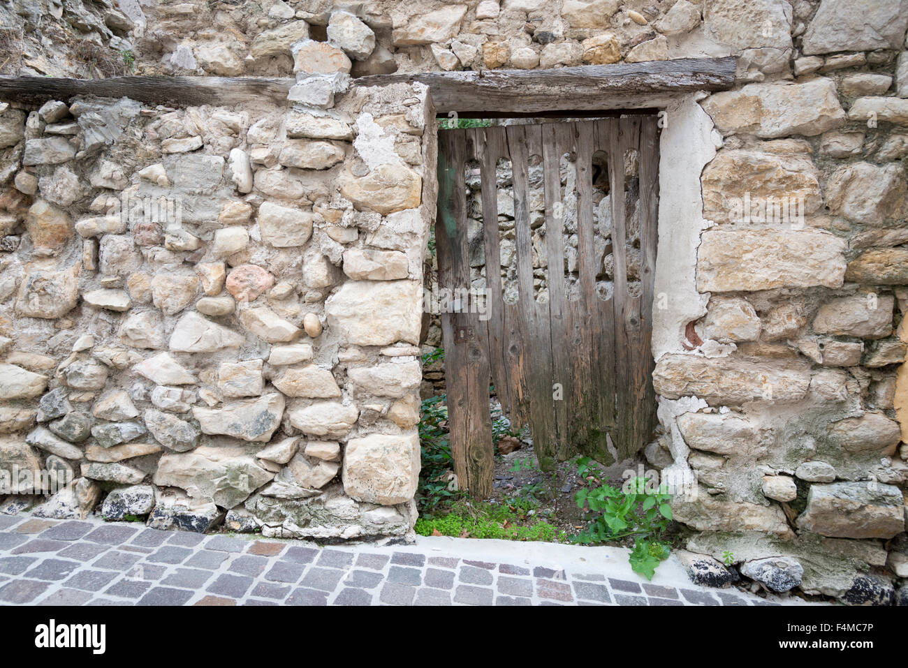 Una puerta de madera en un muro de piedra rústica y rural Fotografía de  stock - Alamy