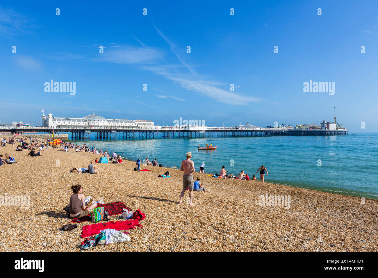 La playa de Brighton, Brighton, Sussex. La playa y el muelle en la tarde de sol, Brighton, East Sussex, Inglaterra, Reino Unido. Foto de stock