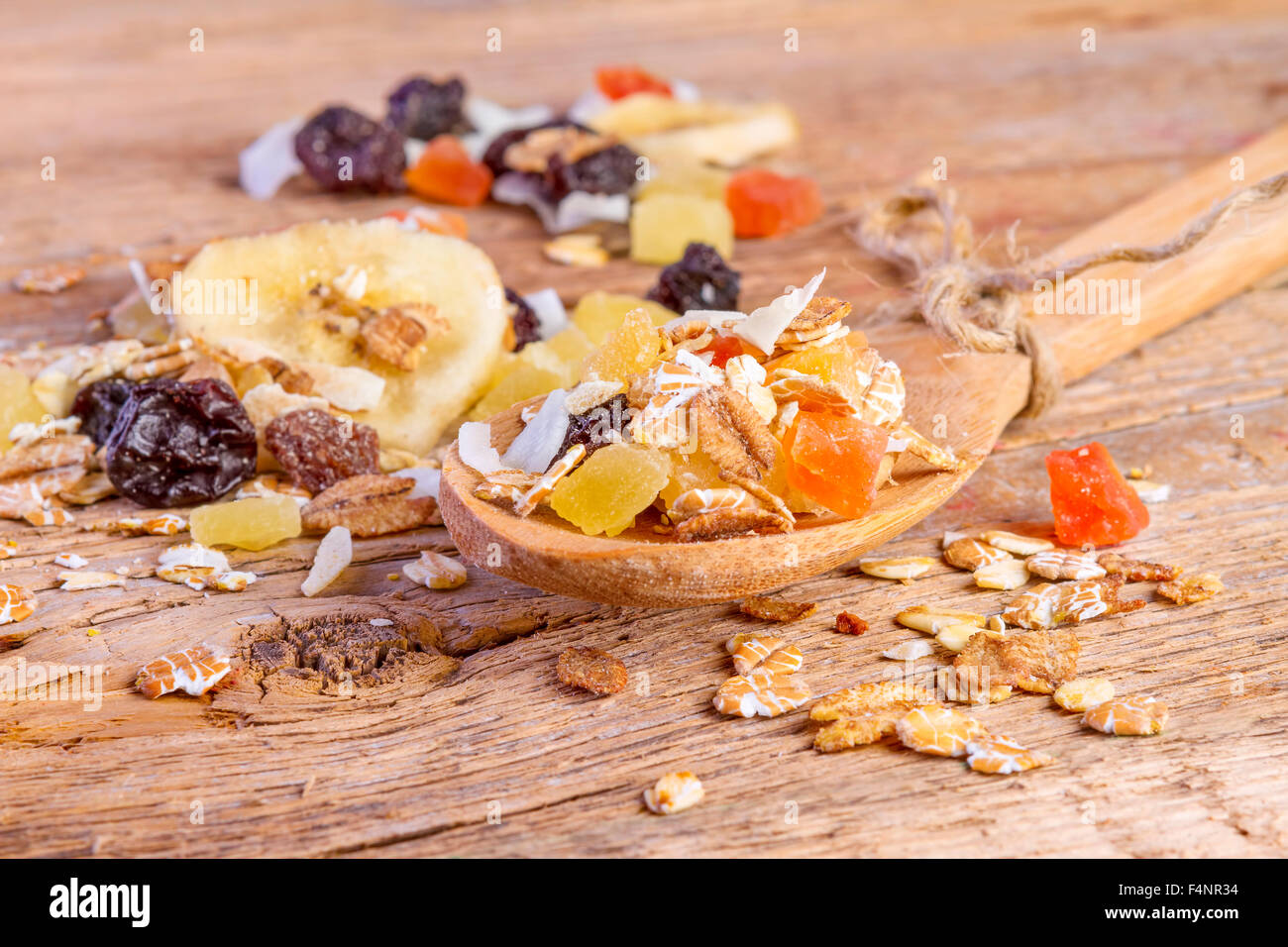Muesli Cereales alimentos en cuchara de madera sobre fondo de madera Foto de stock