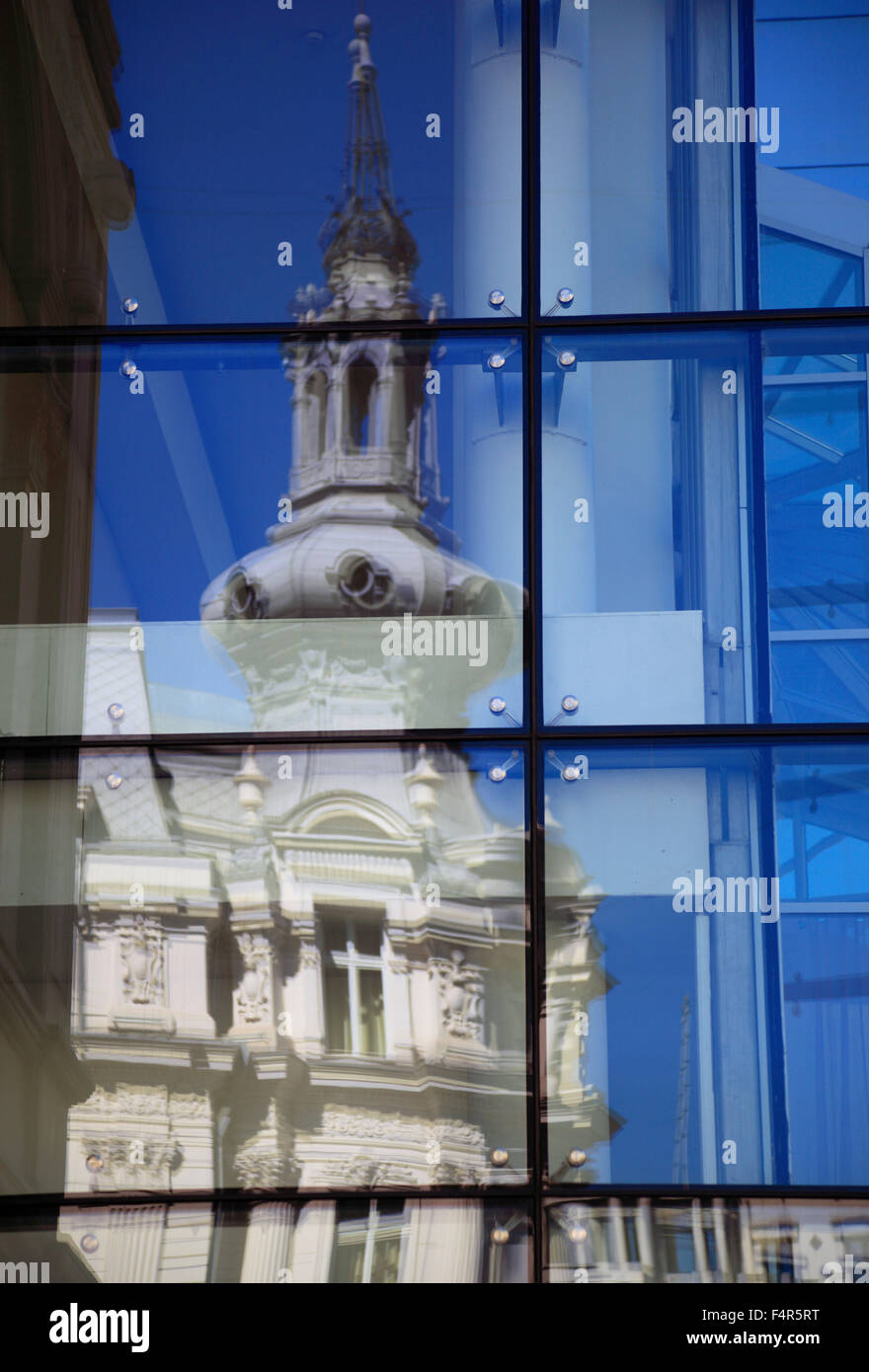 Casa señorial histórica, se refleja en la fachada de vidrio de un moderno edificio de oficinas en Bucarest, Rumania Foto de stock