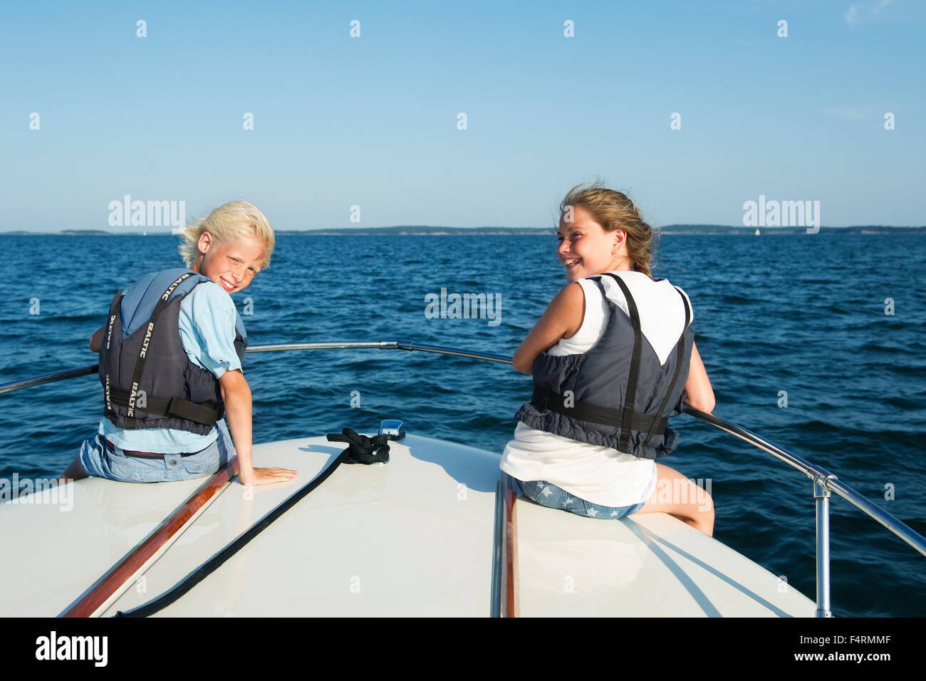 Suecia, Stockholms Skargard, Sodermanland, Jungfrufjarden, Retrato de chico y chica (12-13) en el barco Foto de stock