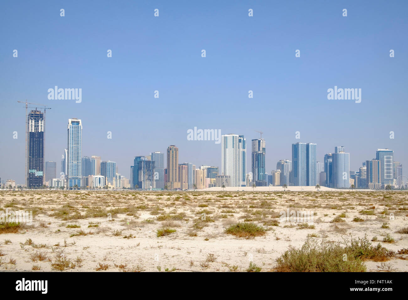 Vistas diurnas de modernos edificios de apartamentos de gran altura desde el desierto en Sharjah, Emiratos Árabes Unidos Foto de stock