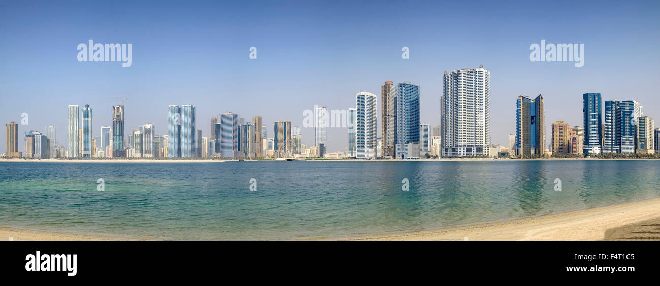 Día de playa y vistas del horizonte de rascacielos modernos edificios de apartamentos a lo largo de la Corniche en Sharjah, Emiratos Árabes Unidos Foto de stock