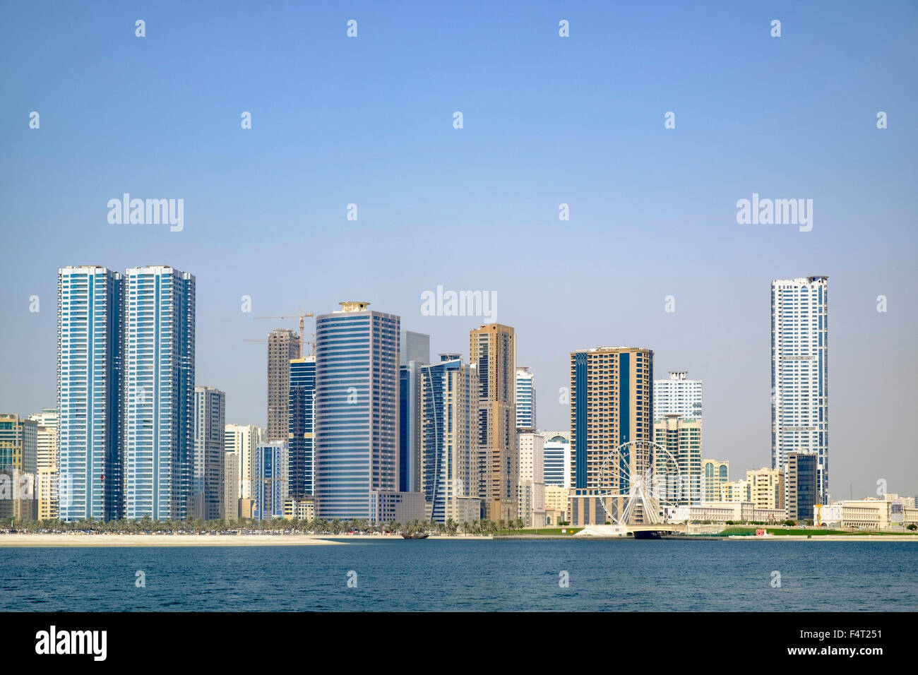 Día de playa y vistas del horizonte de rascacielos modernos edificios de apartamentos a lo largo de la Corniche en Sharjah, Emiratos Árabes Unidos Foto de stock