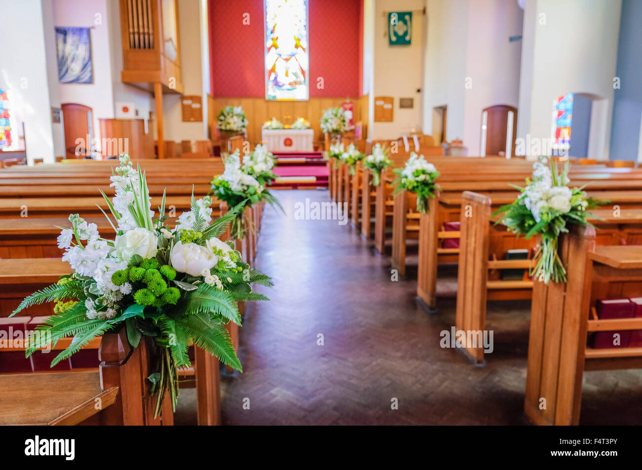 Ramos Floweral decorar pew termina en una iglesia antes de una boda. Foto de stock