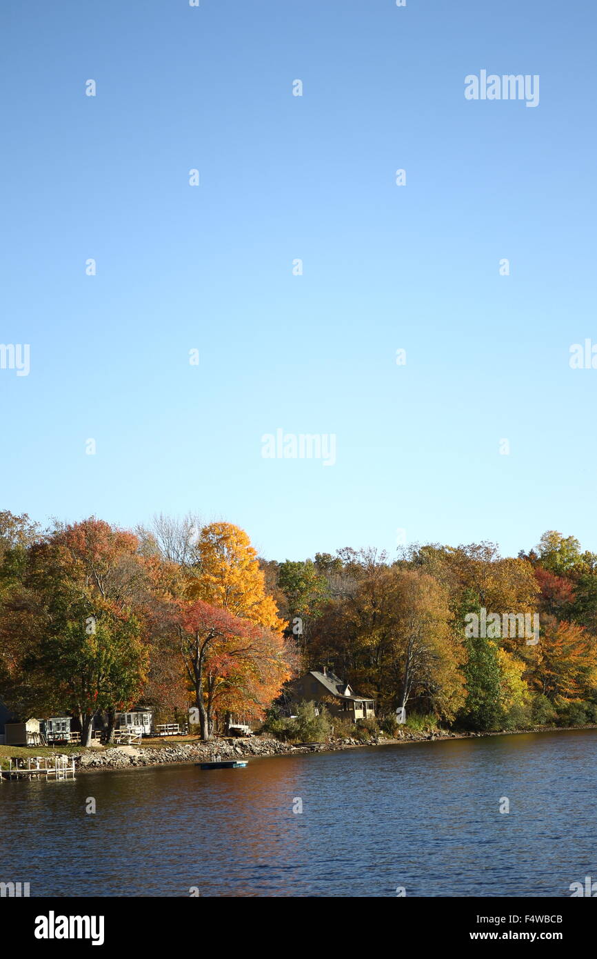 Nueva Inglaterra cambiando hojas caer cerca de una pequeña ciudad sobre el agua. Foto de stock