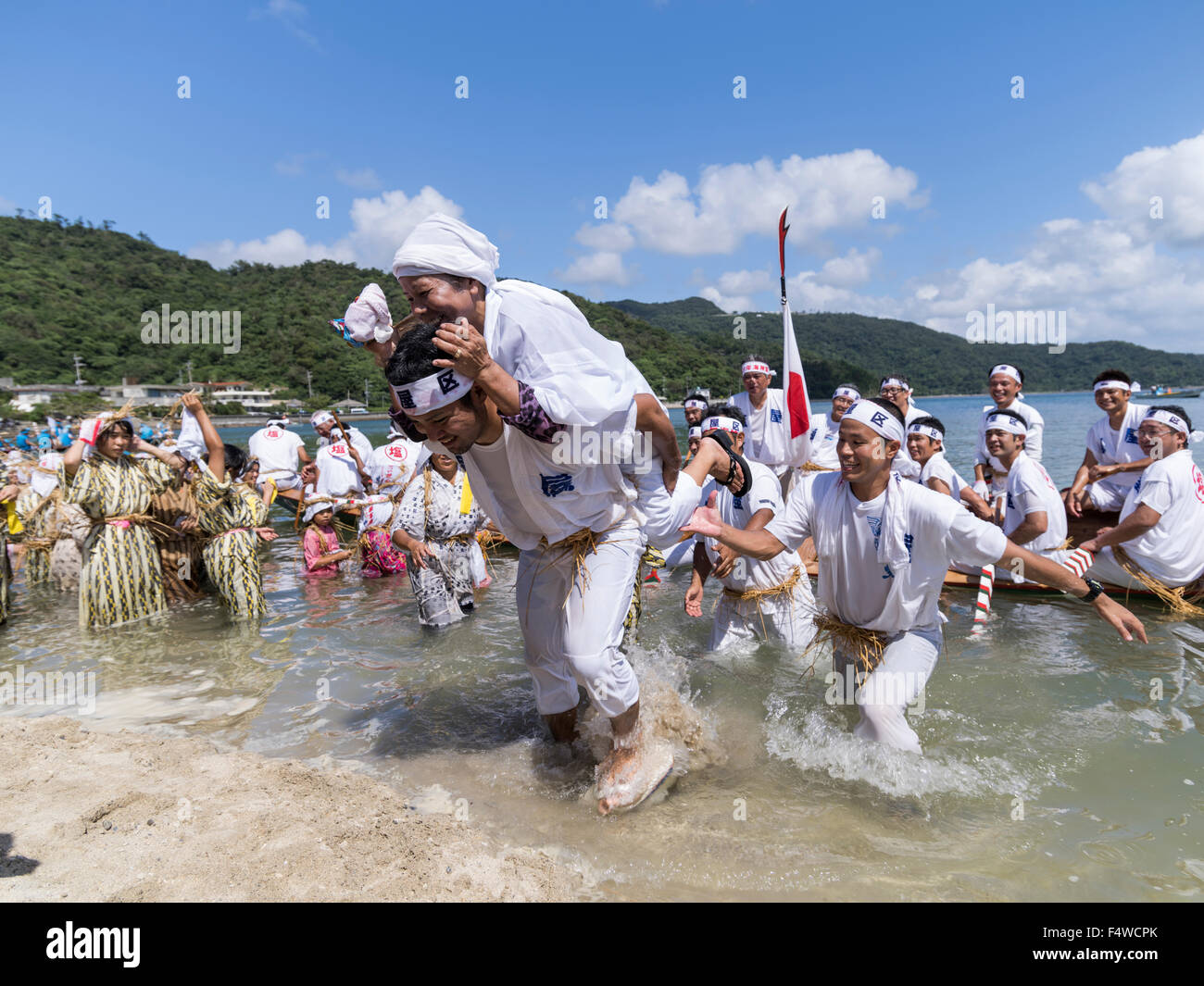Shioya Ungami, un festival anual en Ogimi Village, Okinawa. Ancianos yuta sacerdotisa ayudado desde el Dragon Boat después de la carrera. Foto de stock