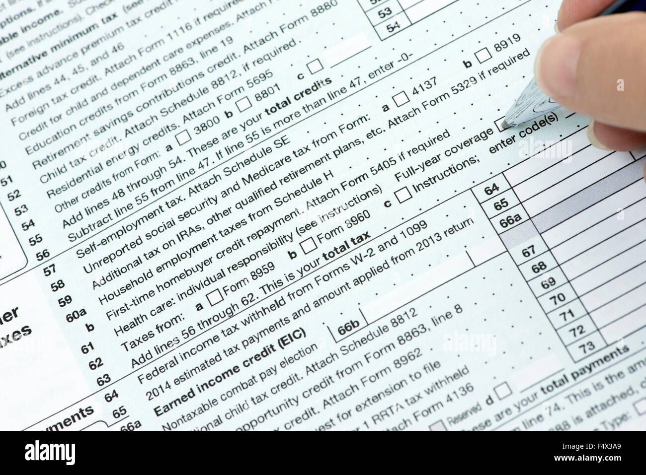Sobre nosotros la línea 61 de la forma 1040 del impuesto sobre la renta con una persona revisando su cobertura médica de verificación. Foto de stock