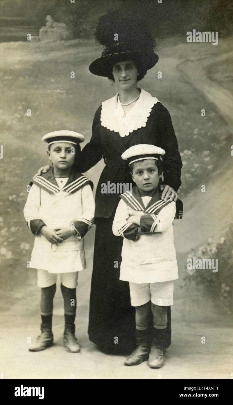 Una mujer elegante, vestida de negro, con un gran sombrero y dos niños  vestidos de marineros, Italia Fotografía de stock - Alamy