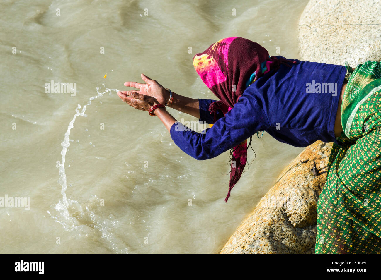 Una hembra de peregrino en los bancos del río Ganges está orando, ofreciendo el agua bendita Foto de stock